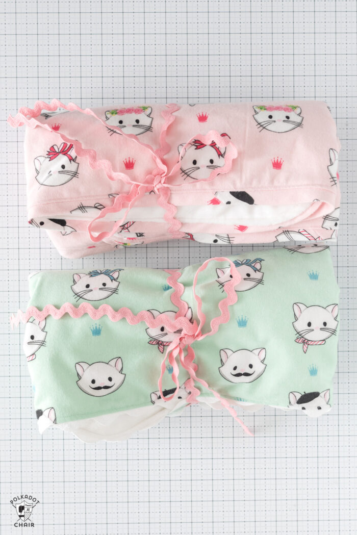 pink and mint flannel blankets on white table top with small toy cat
