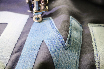 close up of scribble stitching on denim letter