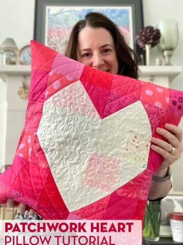 woman holding Quilted red pillow with white heart in the center