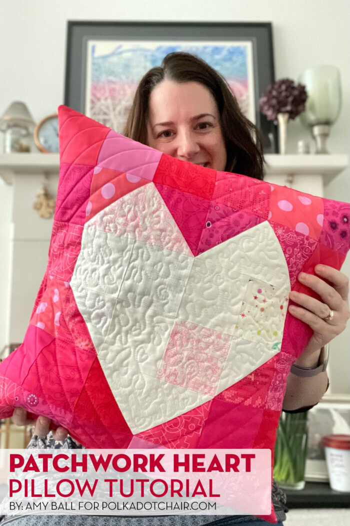 woman holding Quilted red pillow with white heart in the center