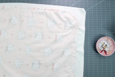 two pieces of fabric, right sides facing on cutting mat with pins