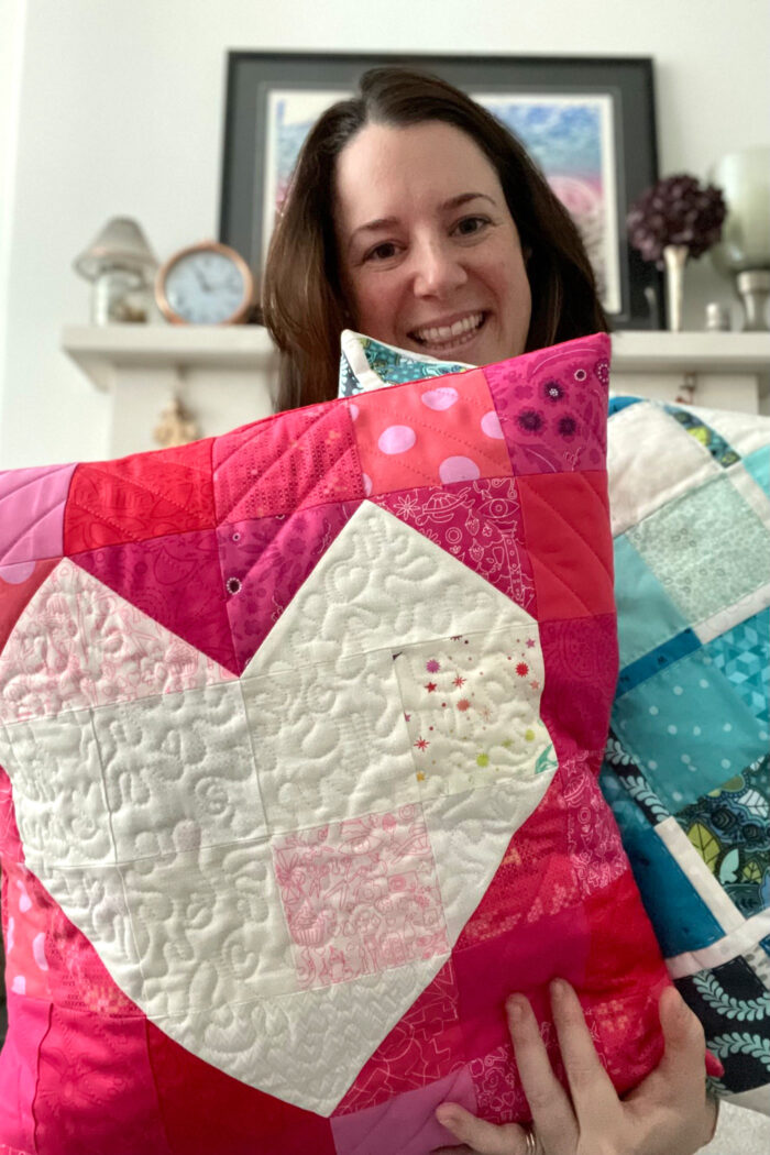 woman holding Quilted red pillow with white heart in the center