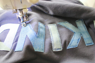 close up of sewing machine sewing letters