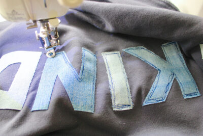 close up of sewing machine sewing letters