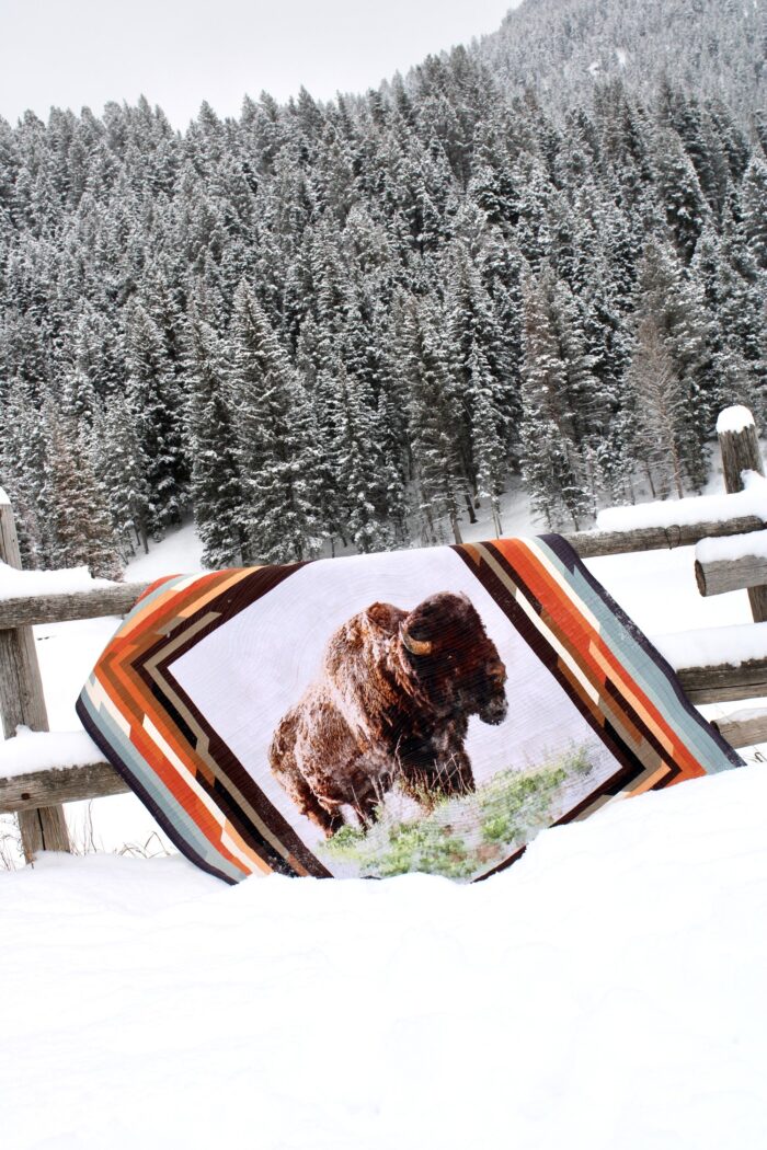quilt with illustration of buffalo on fence in snow
