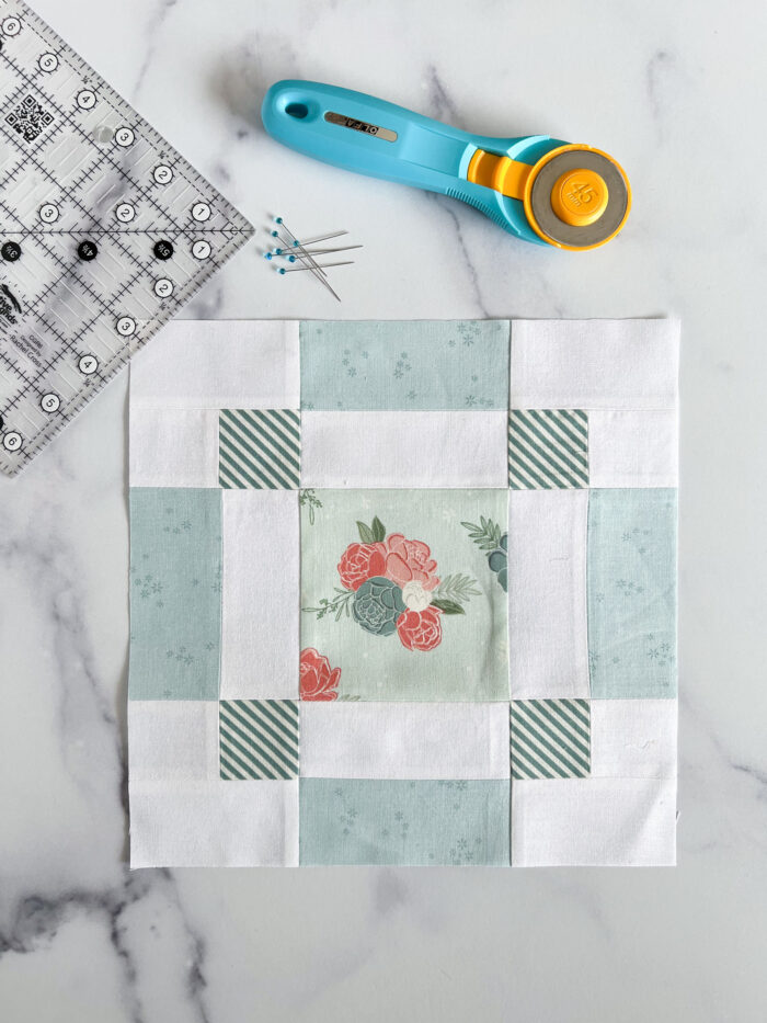 quilt block made from floral and aqua fabric on white marble table
