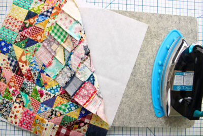 patchwork squares and iron on gray ironing board