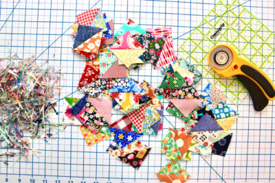 pressed half square triangle quilt blocks on white cutting mat