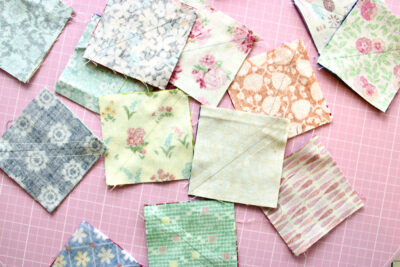 squares of fabric on pink cutting mat