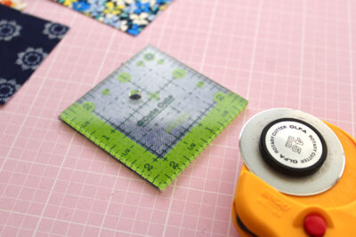 quilt ruler and rotary cutter on pink cutting mat