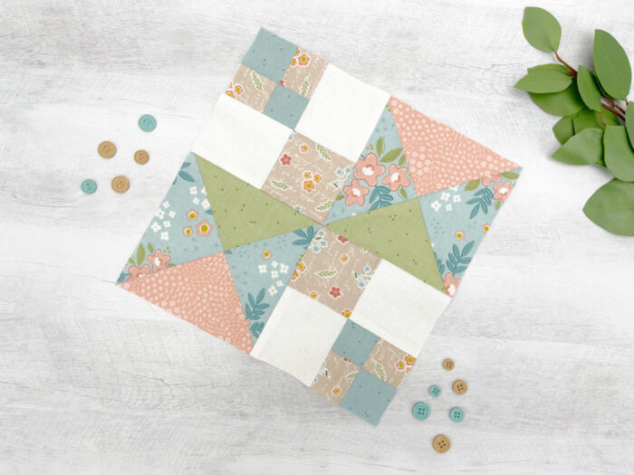 peach and sage quilt block on wood table with buttons