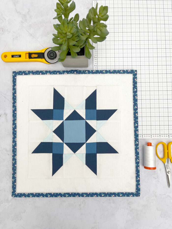 blue and white star quilt block on white table
