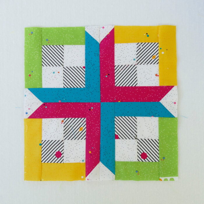 brightly colored quilt block on white table