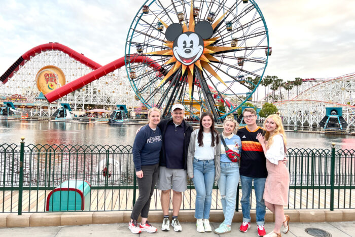 Family posed in front of ferris wheel at Disneyland