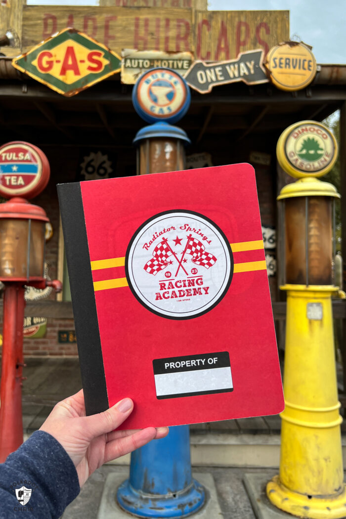 close up of Cars notebook in front of scene at Cars Land