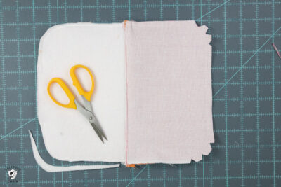 scissors on top of white fabric on cutting mat