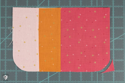 cut pieces of pink and orange fabric on cutting mat