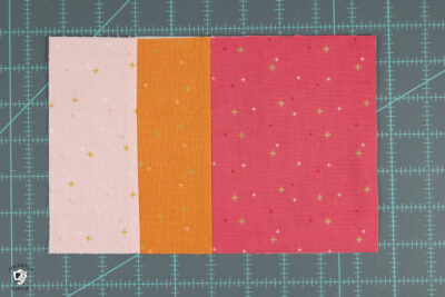 cut pieces of pink and orange fabric on cutting mat