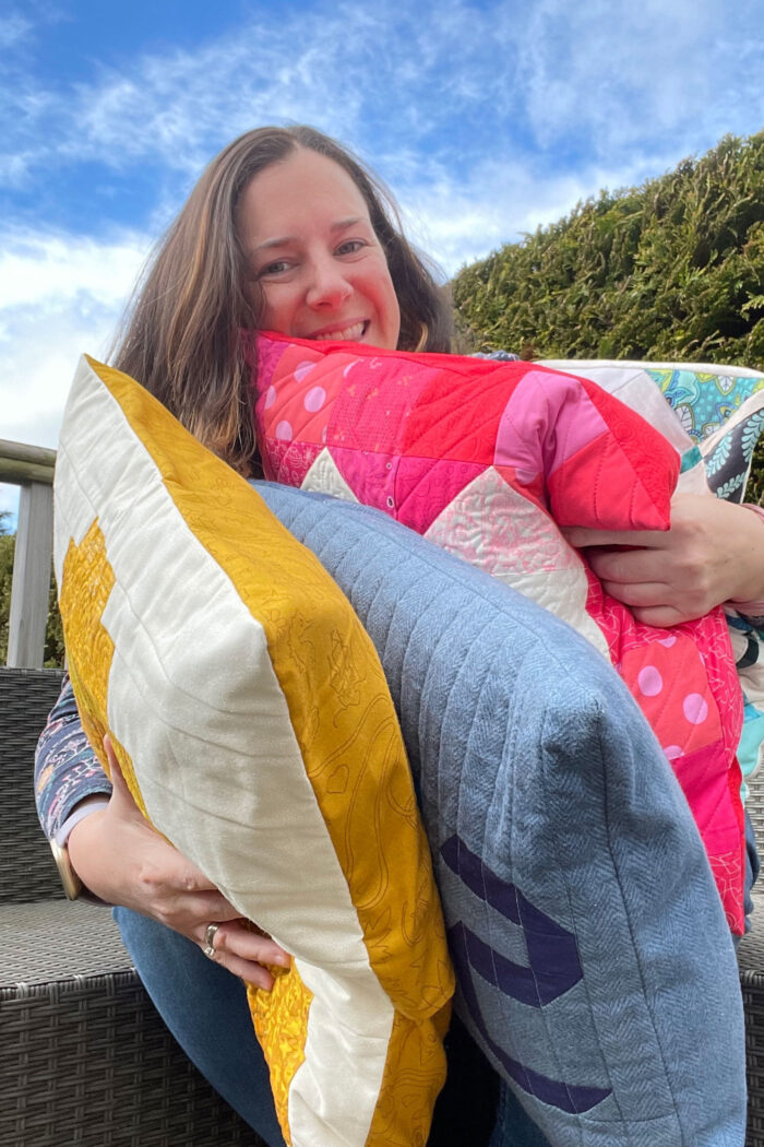 woman holding colorful quilted pillows