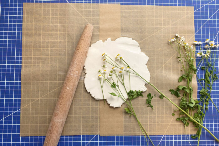 imprint of flowers rolled into air dry clay on brown paper