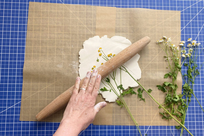 imprint of flowers rolled into air dry clay on brown paper