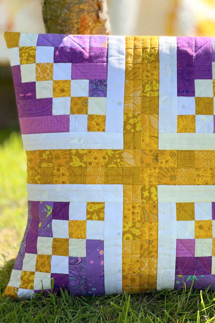 close up of purple and gold union jack patchwork pillow