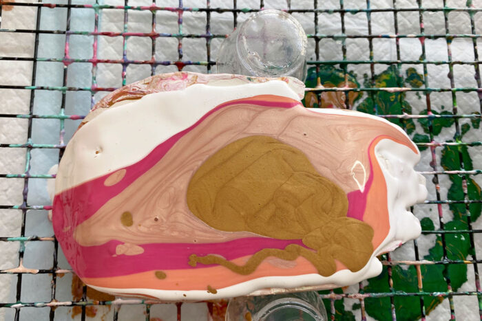 pink, white and gold paint poured over dish