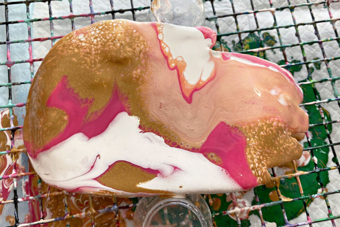 pink, white and gold paint poured over dish