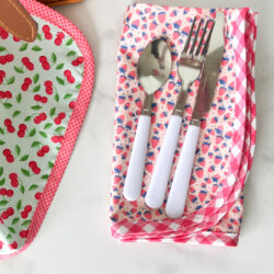 Pink fabric napkin with utensils on white marble table