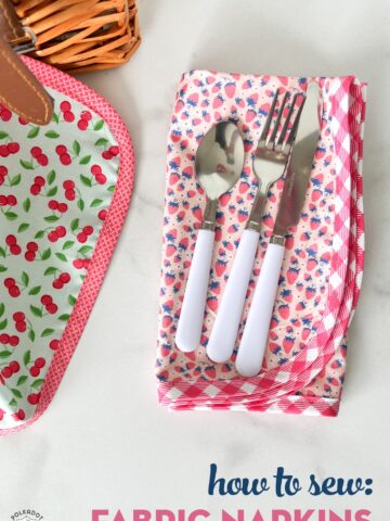 Pink fabric napkin with utensils on white marble table