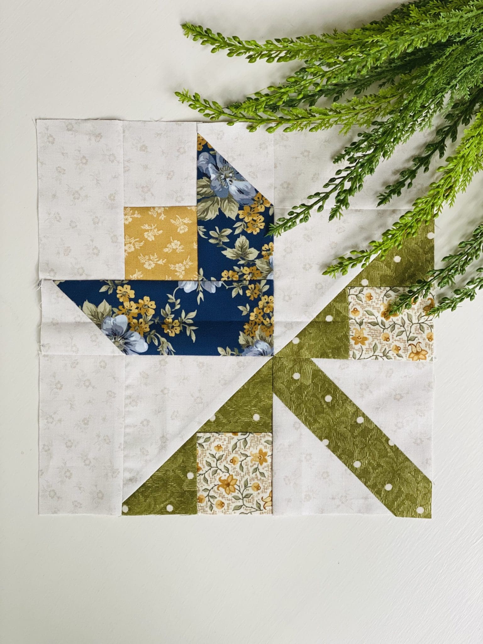 green and yellow flower quilt block on white table