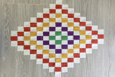 colorful pieced quilt block in red, yellow, green and purple