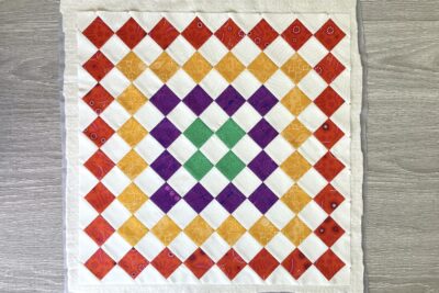 colorful pieced quilt block in red, yellow, green and purple