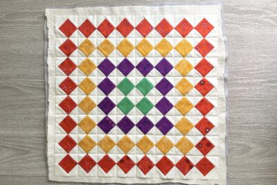 colorful pieced quilt block in red, yellow, green and purple
