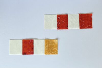 squares of red, cream and yellow fabric on white table