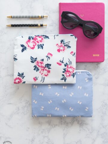 floral and ribbon print zip bags on marble table with office supplies