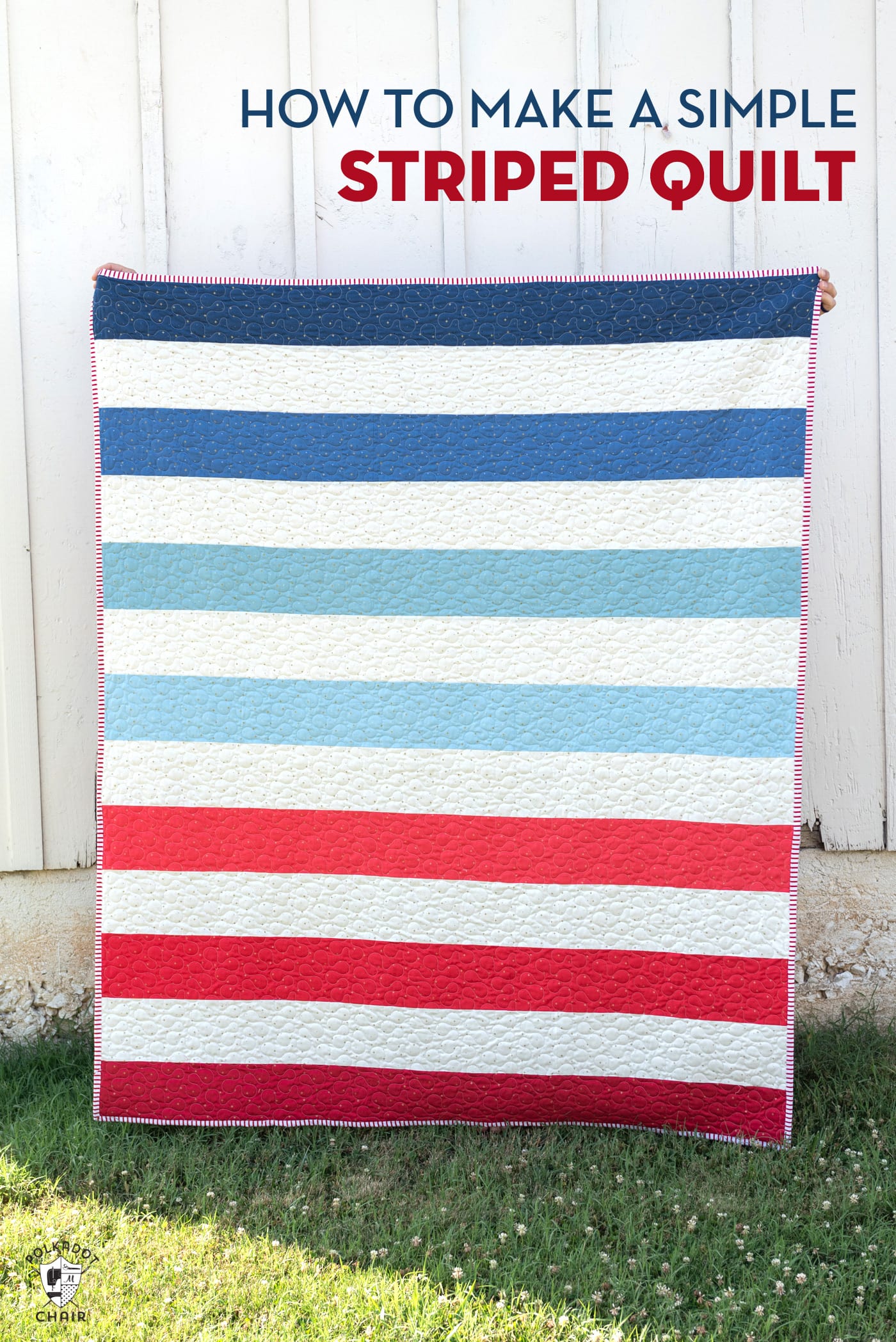 red white and blue striped quilt in front of white barn