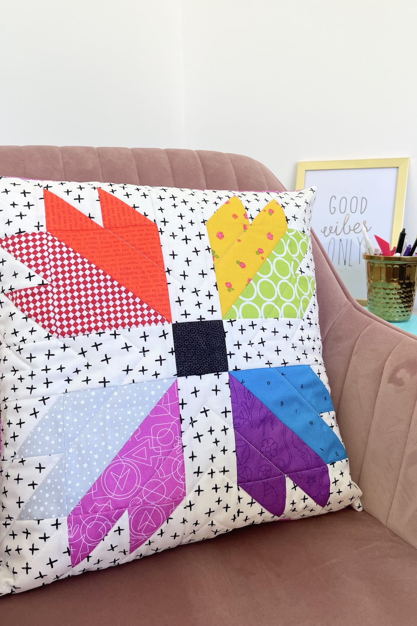 colorful quilted bear paw pillow on table with sewing notions