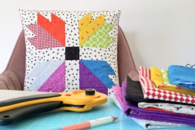 colorful quilted bear paw pillow on table with sewing notions