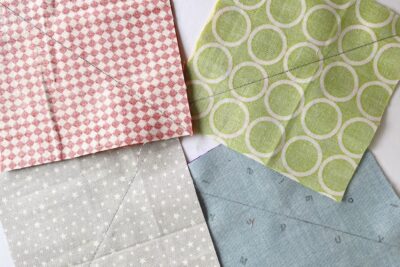 squares and triangles of yellow, blue, green, and red fabric on white table