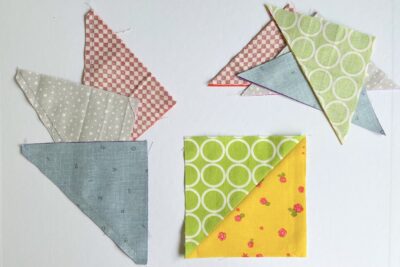squares and triangles of yellow, blue, green, and red fabric on white table
