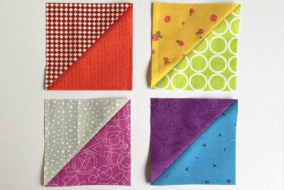 squares and triangles of yellow, blue, green, and red fabric on white table