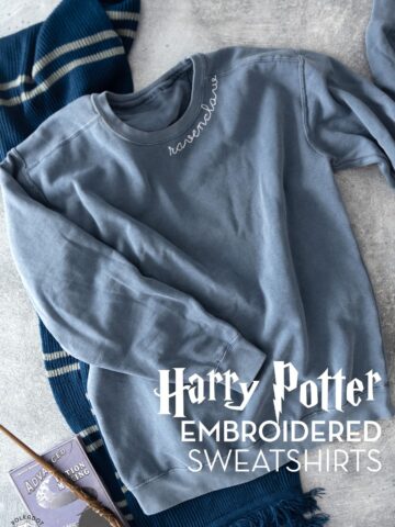 blue sweatshirt and blue and gray scarf on gray tabletop