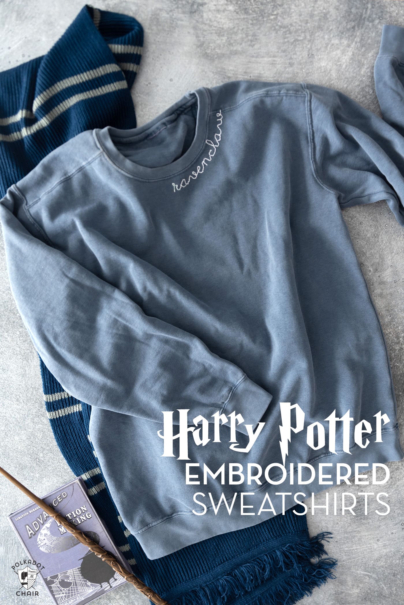 navy sweatshirt, navy and gray scraf and book on gray tabletop