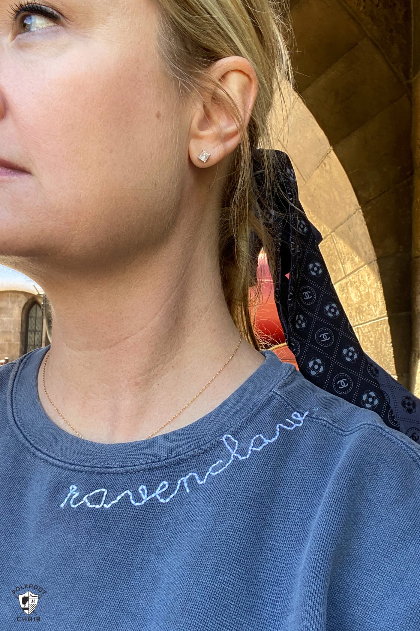 close up of woman wearing navy sweatshirt with ravenclaw embroidered on the collar