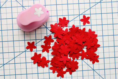 red punched flowers on white cutting mat