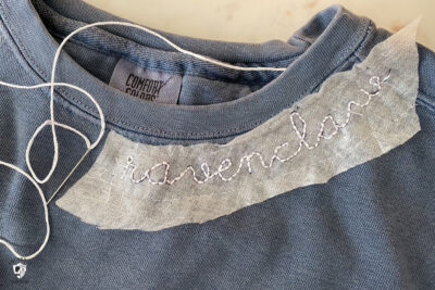 close up of hand embroidery on blue sweatshirt
