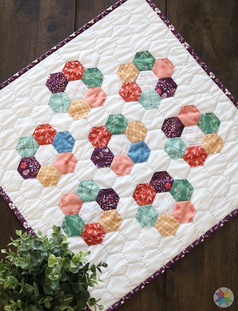 small hexagon mini quilt on wood table