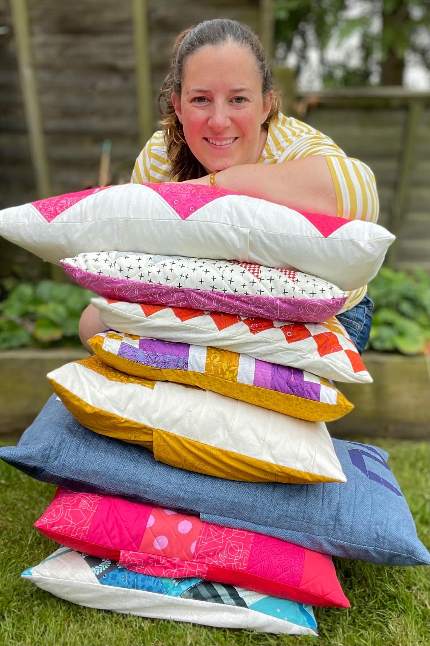 woman sitting next to a pile of pillows