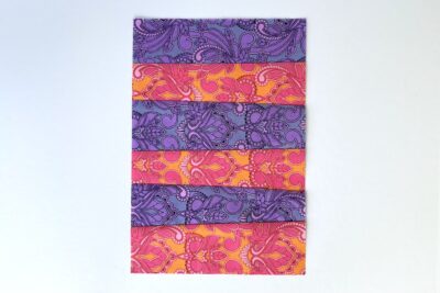 purple and red fabric strips on table